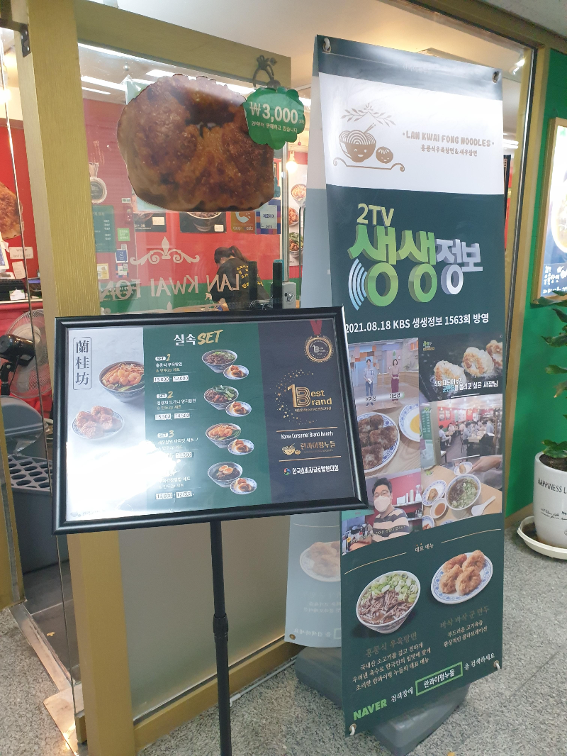 음식점 앞에 베너와 스탠드 POP 설치대가 있다. 메뉴들을 소개하고 있다.