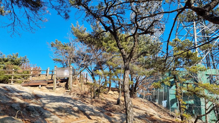 푸른하늘, 왼쪽에 데크계단, 가운데 2보루 안내문, 우측에 송신탑 하부 구조물, 건물,