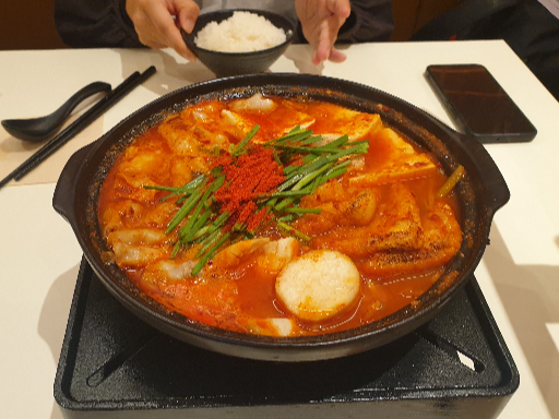 무쇠 냄비 안에 전골이 들어 있다. 밥 공기가 일식집 같다.