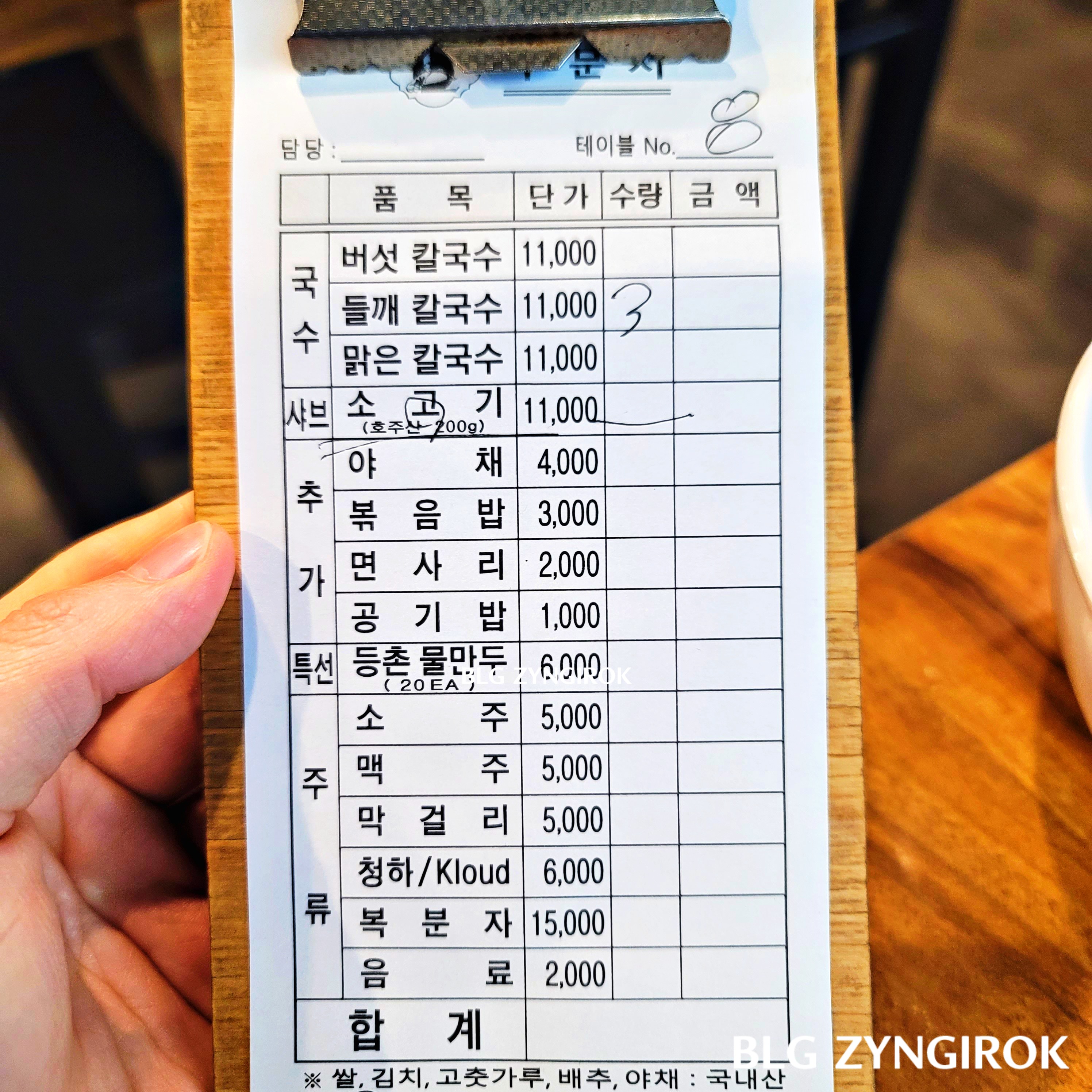 등촌칼국수 메뉴판을 들고 있는 모습이다.