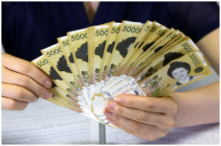 "사람이 한국 5만 원권 지폐 다발을 양손에 들고 있는 모습. 적금, 저축, 목돈 마련을 상징하는 이미지"