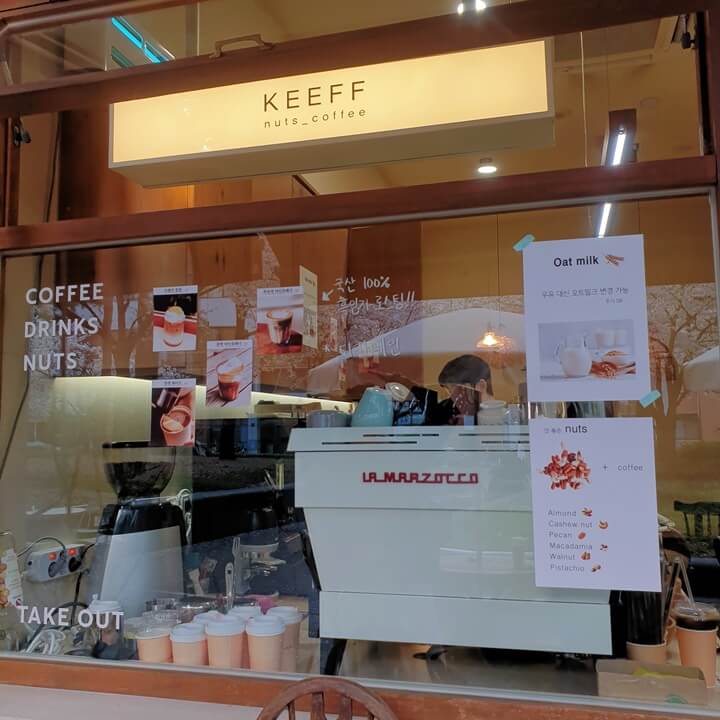 keeff의-간판과-커피머신이-유리창을-통해-보인다