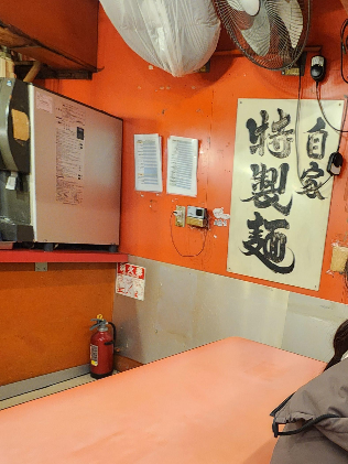 주황색 벽면에 한자가 쓰여있는 가게 내부