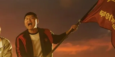 깃발을 들고 소리치고 있는 드라마 소년시대에서 강대진 역을 연기하는 배우 허건영