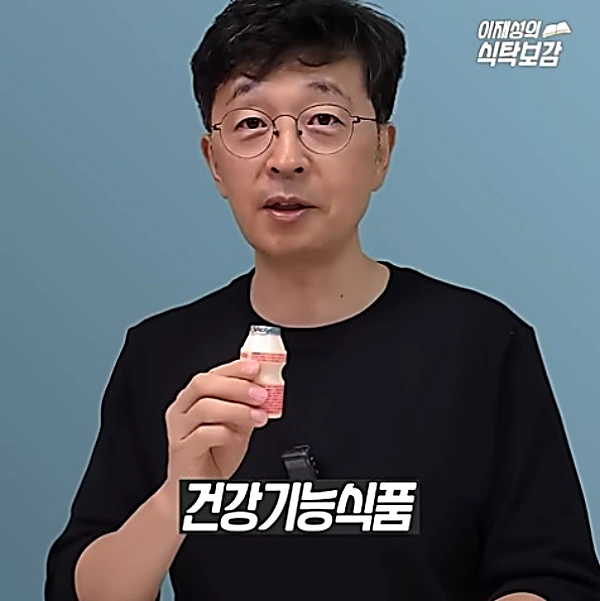 초록 뚜껑의 야쿠르트를 손에 든 모습