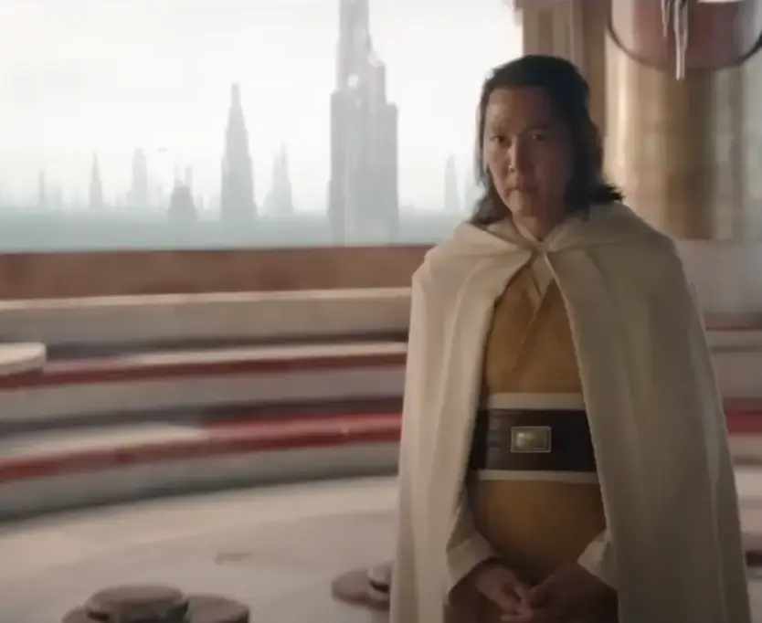 흰망토 노란 옷을 입은 이정재가 서있는 모습