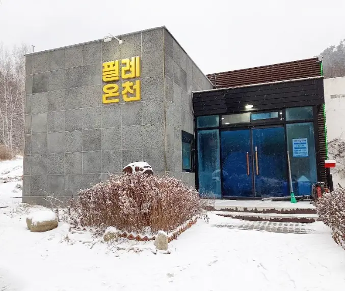 겨울방학 국내 여행지-
금색 필례온천 간판이 붙은 눈밭 속 온천 건물