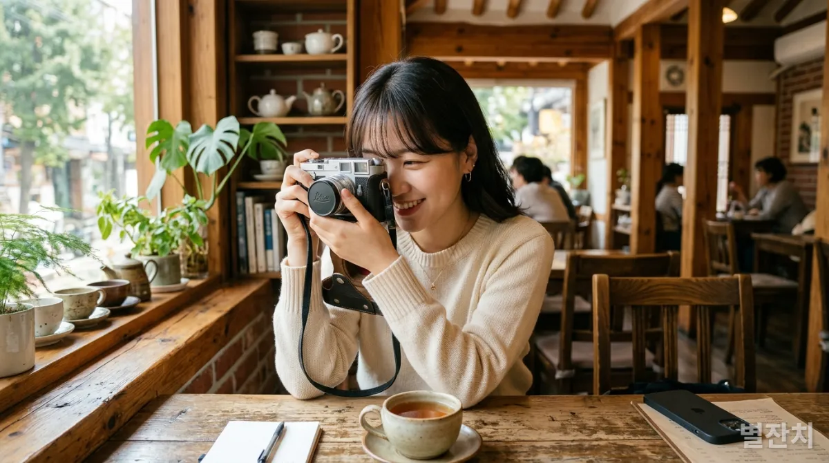 필름 카메라를 들고 아날로그 감성을 즐기는 젊은 한국 여성과 배경의 스마트폰