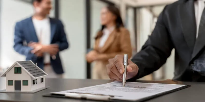 전세 계약서를 작성하고 있는 공인중개사와 신혼부부의 모습
