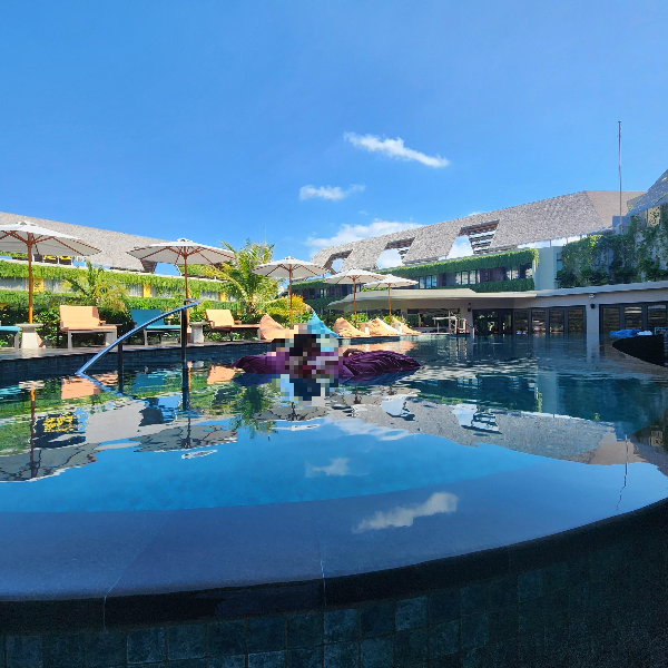 수영장에 떠 있는 아내. 수영장 밖으로는 썬베드가 놓여있다.