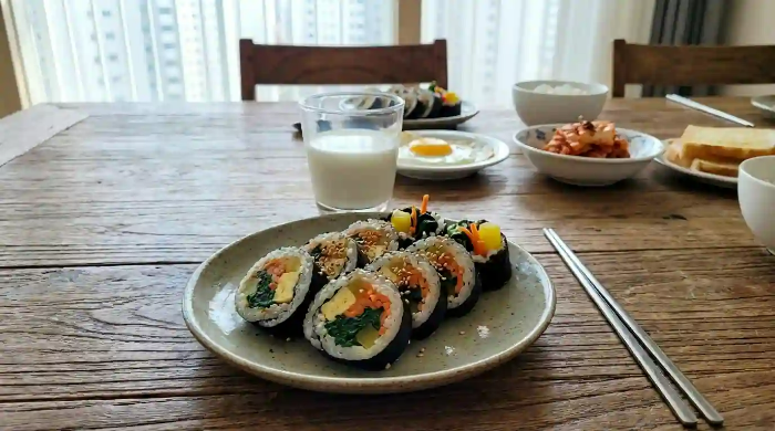 식탁 위에 김밥, 우유 1잔이 놓여 있음