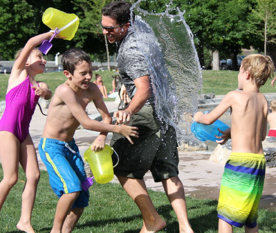 여러명이 물통에 있는 물을 서로에게 부으며 물 싸움하는 사진