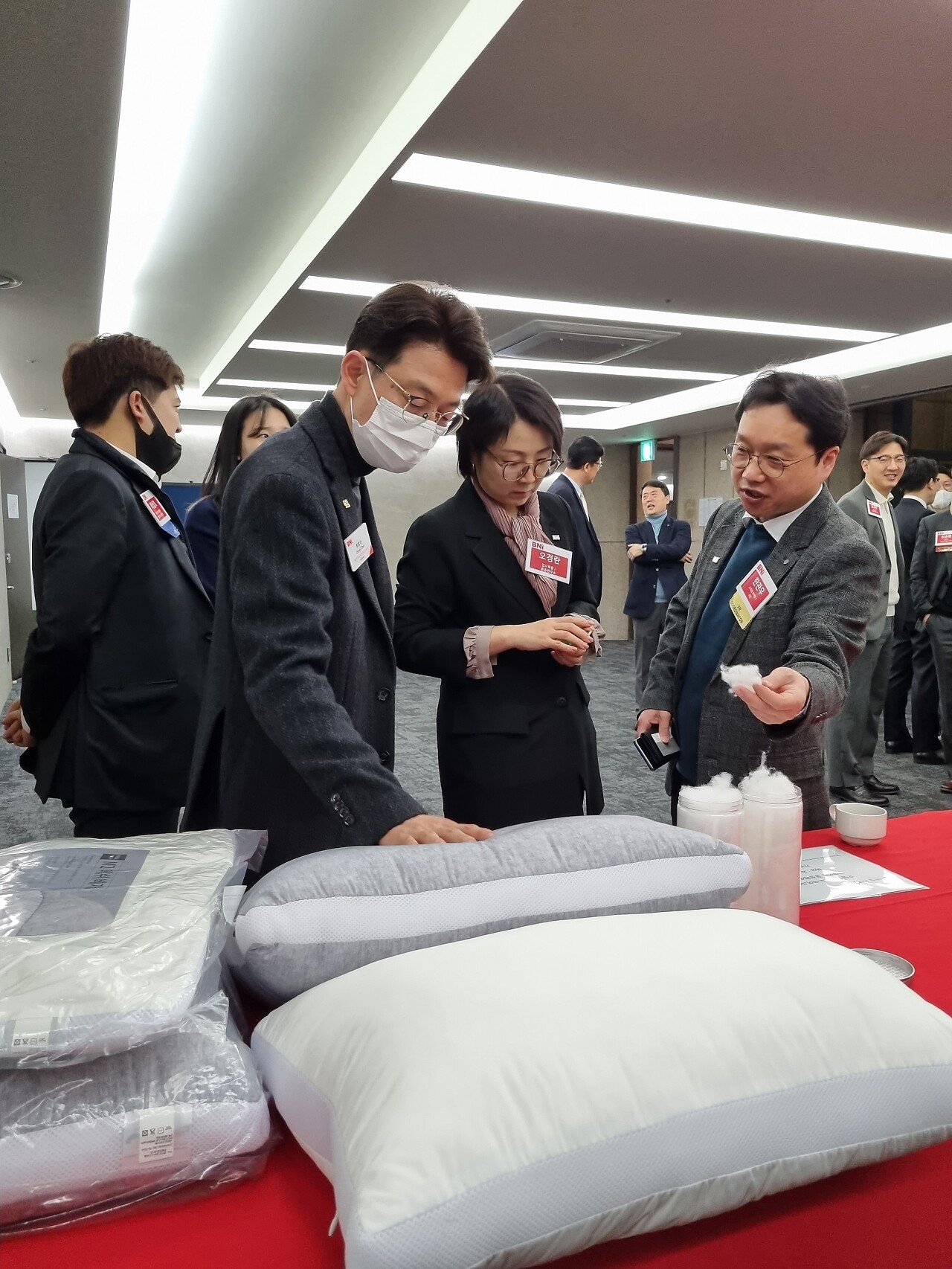 쇼핑몰마케팅 한관우 대표가 더한 온라인 쇼핑몰에서 판매하고 있는 메쉬베개의 상품의 호텔식베개와 같은 부드러움을 솜을 만지며 설명하고 있습니다.
