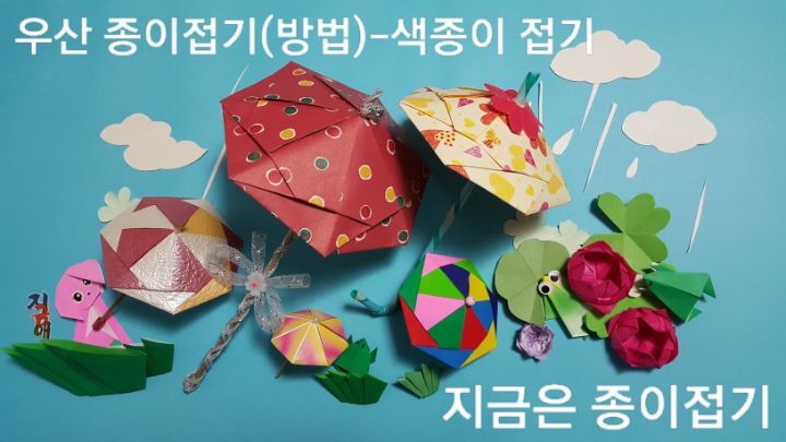 우산 종이접기 방법의 완성 모양이며, 크고 작은 우산이 다섯개 있고 개구리와 연꽃이 있는 충경의 비오는 날입니다.