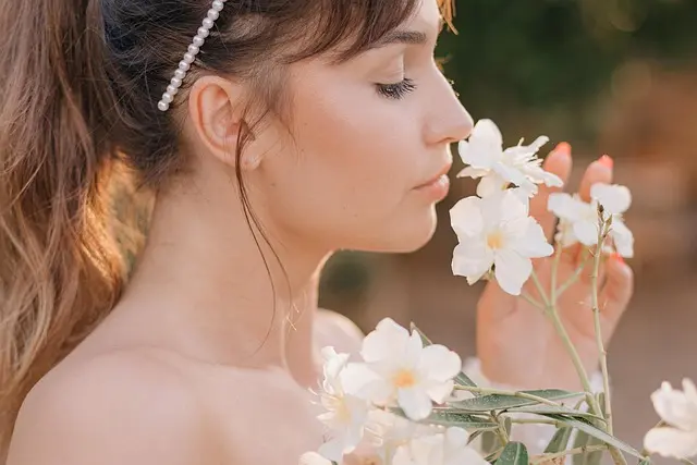 하얀 꽃 향기를 맡는 여성의 옆모습