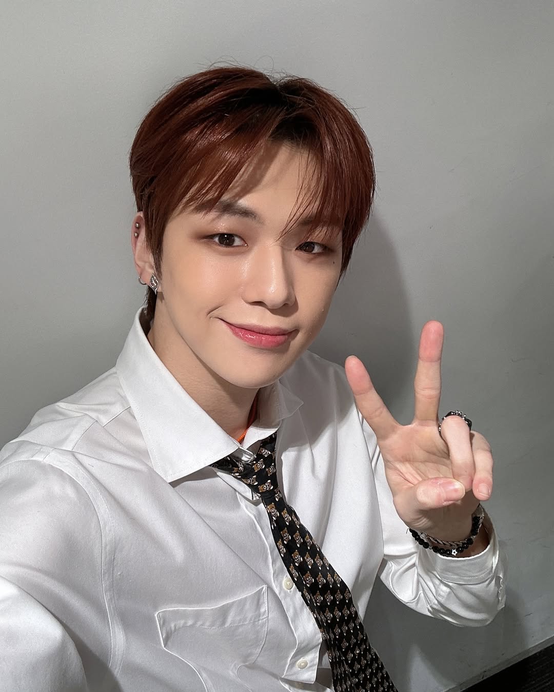 흰 셔츠에 포인트 곰돌이 넥타이를 매고 셀카를 찍고 있는 워너원 강다니엘