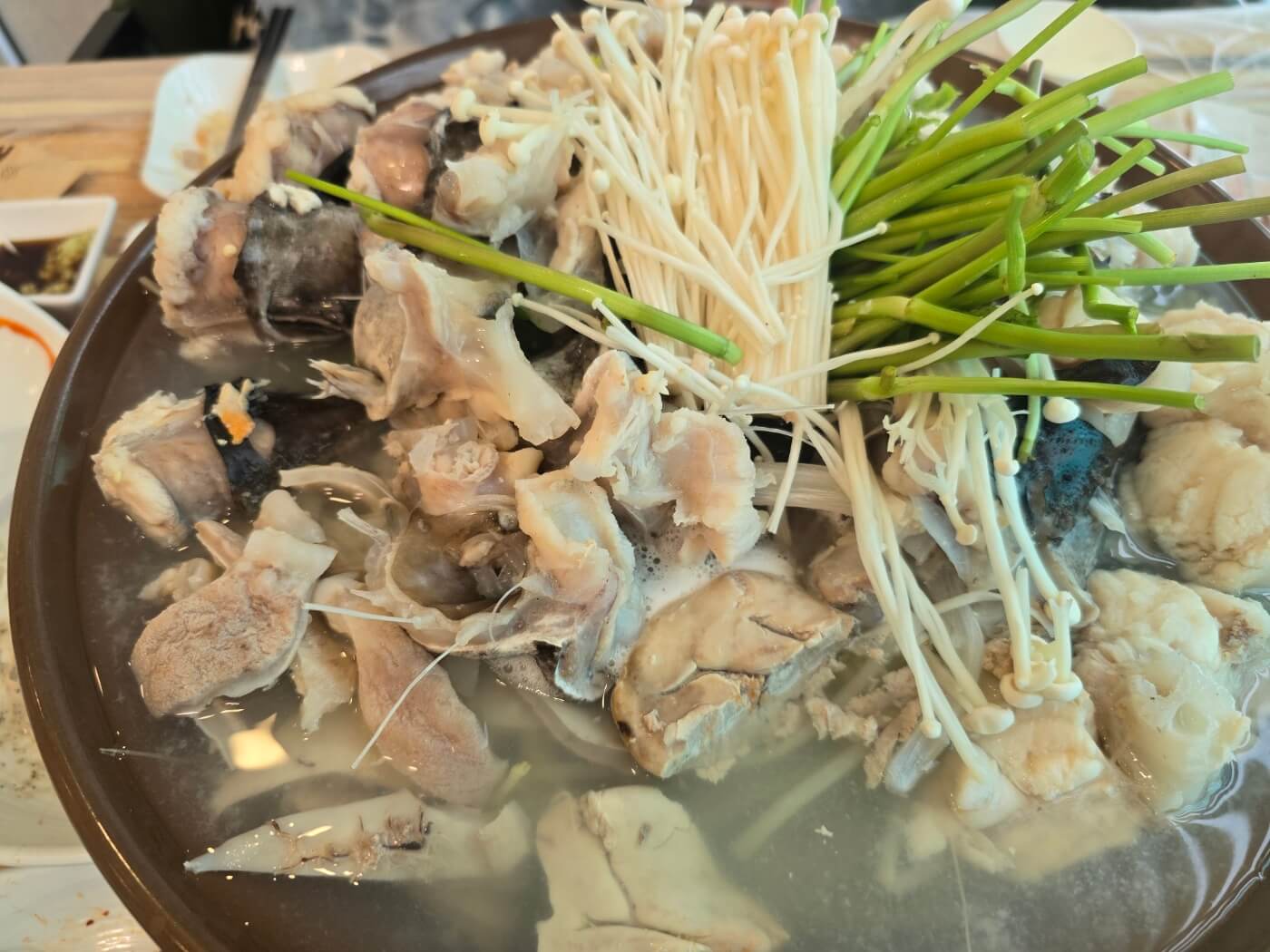대왕왕 아구찜 의 생아구 수육. 아구 위에 팽이버섯 미나리가 올라가 있는 모습