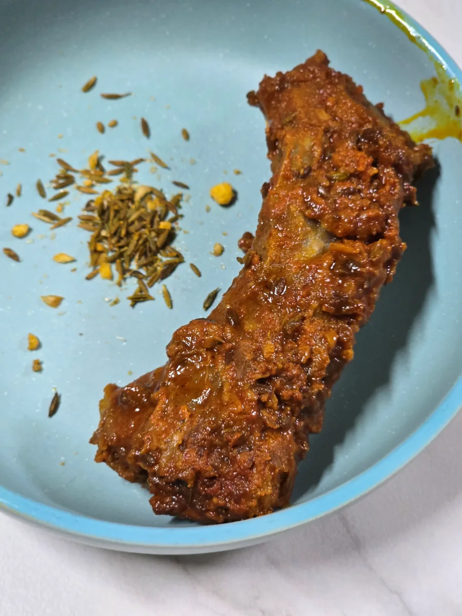 앞접시에 옮겨 담은 쯔란 등갈비 옆에 쯔란 시즈닝이 뿌려진 사진