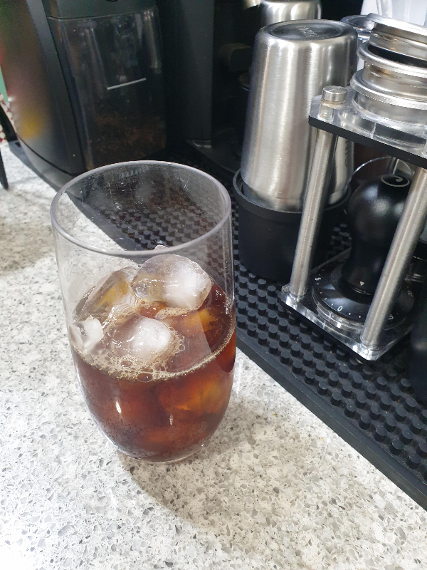 얼음이 담긴 컵에 커피가 추가된 모습.