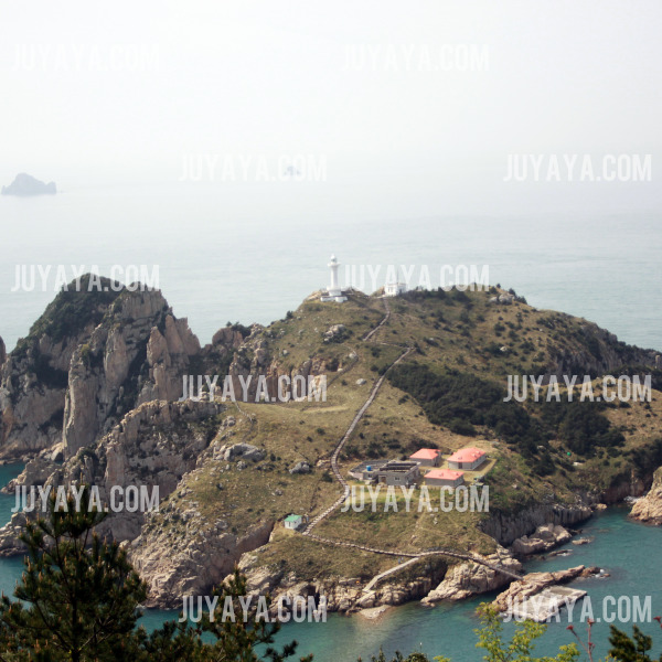 A clear view of Somaemuldo Island, showing the lighthouse, rocky cliffs, and green landscape along the coastline.