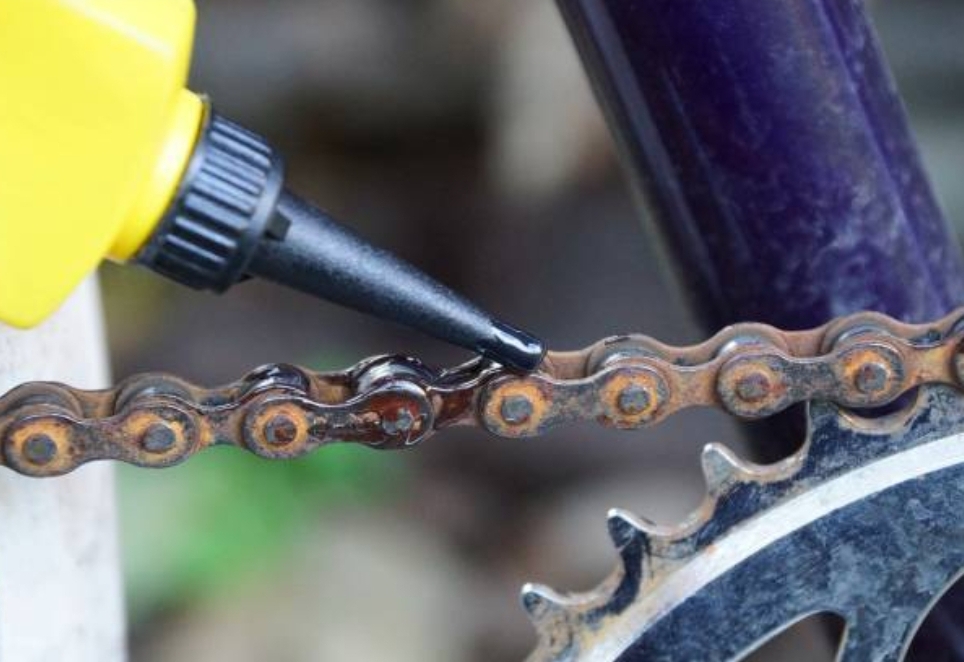 녹슨 자전거 체인데 오일을 바르고 있음