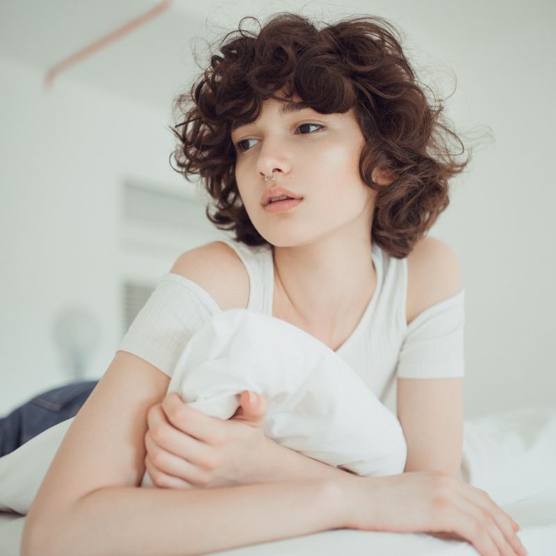 침대에서-왼쪽을-바라보며-엎드려-있는-갈색-단발-여성