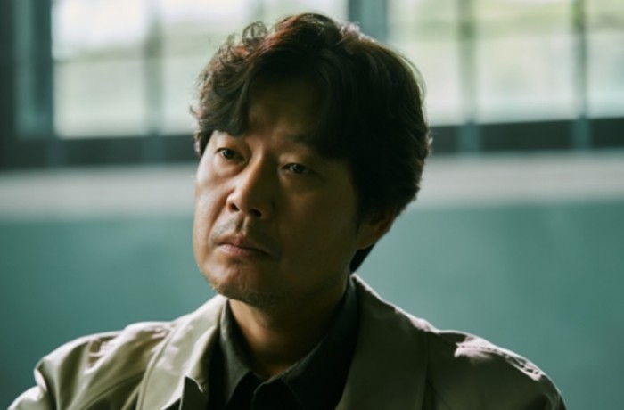유재명 배우가 뭔가를 보는 모습