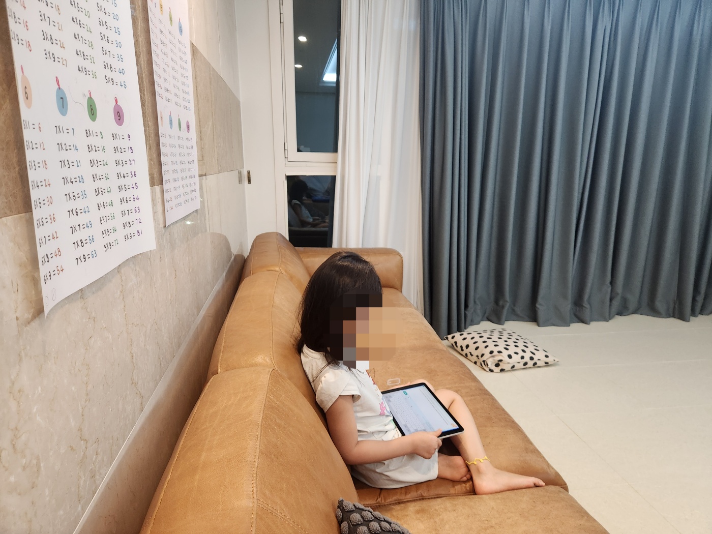 테블릿pc에서 영어로 문장을 쓰고 있는 딸