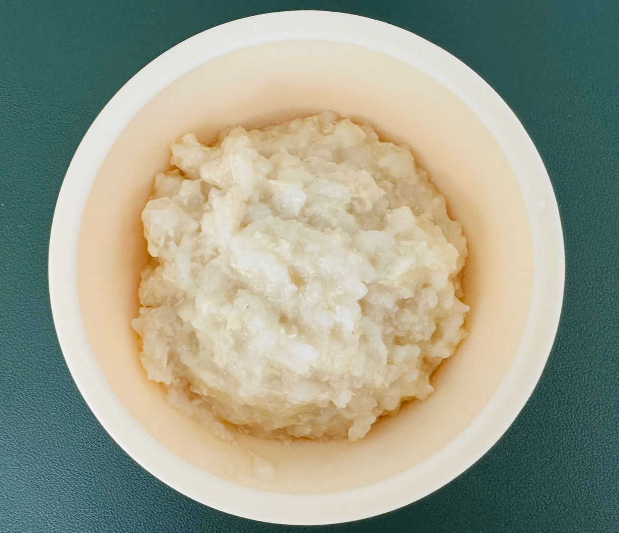 닭고기고구마감자죽을 담은 흰색 이유식 그릇, 부드럽게 잘 익은 죽의 질감이 고르게 퍼져 있다