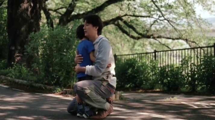 공원에서 아버지가 아들을 안고 있다