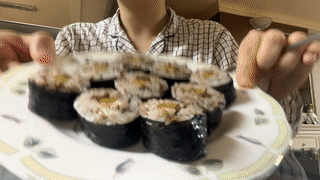 잠옷을-입고-있는-여성이-김밥을-먹고-있습니다.