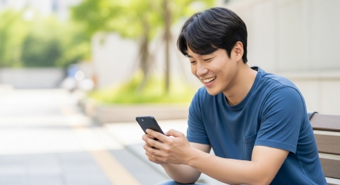 기쁜 표정으로 스마트폰을 보는 청년