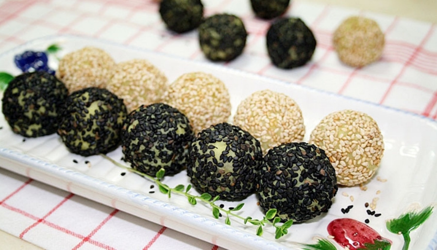 검은깨와 흰깨를 이용하여 만든 깨경단을 희고 네모난 접시에 5개씩 나란히 놓아둔 것을 놓아두고, 그 옆에는 깨경단 5개를 바닥에 놓아두고 찍은 사진