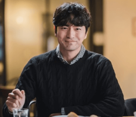 배우 이진욱이 앉아서 웃고있는 사진입니다.