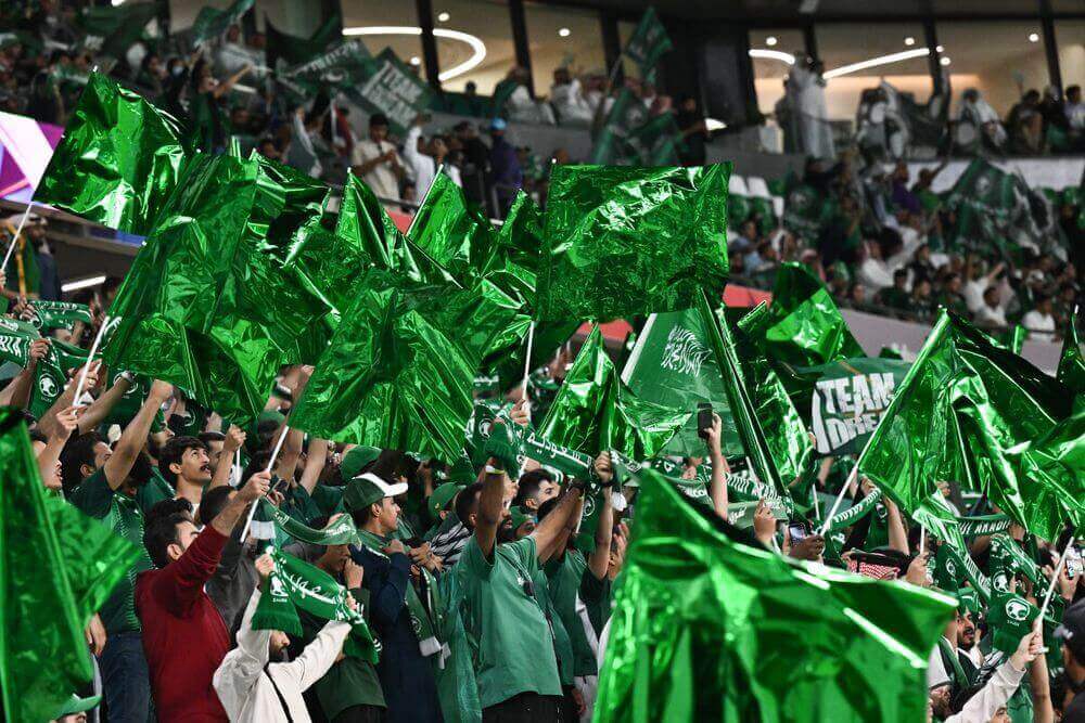 녹색 깃발을 들고 응원하는 사우디아라비아 관중들