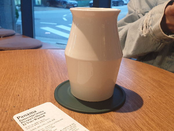 테이블 위에 커피 잔이 올려져 있다. 파나마 게이샤 노트도 보인다.