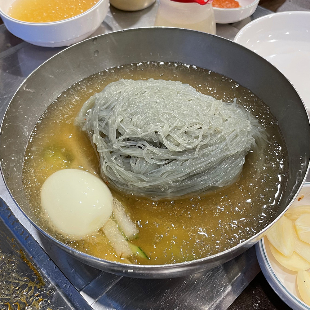 달걀과-물냉면이-담긴-스테인리스-그릇이-있습니다.