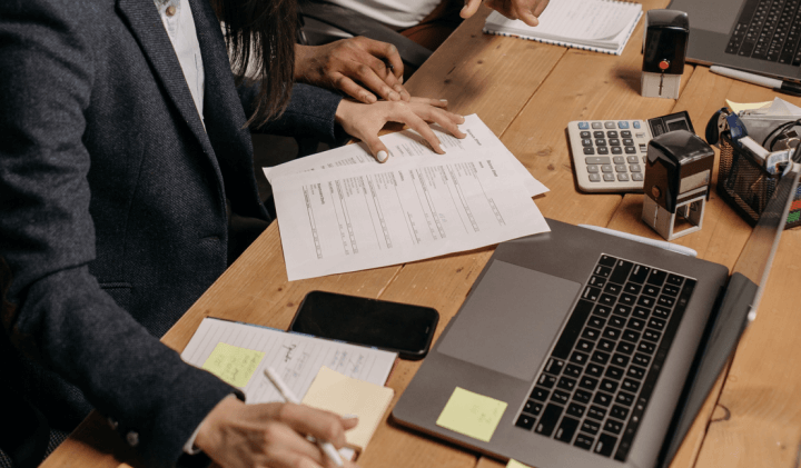 서류를 확인하며 노트북으로 작업하는 사람들