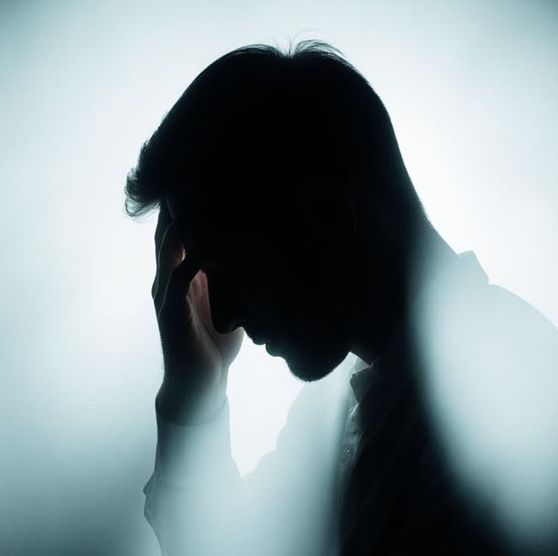 스트레스를 받아 머리를 감싸 쥐고 있는 사람의 실루엣