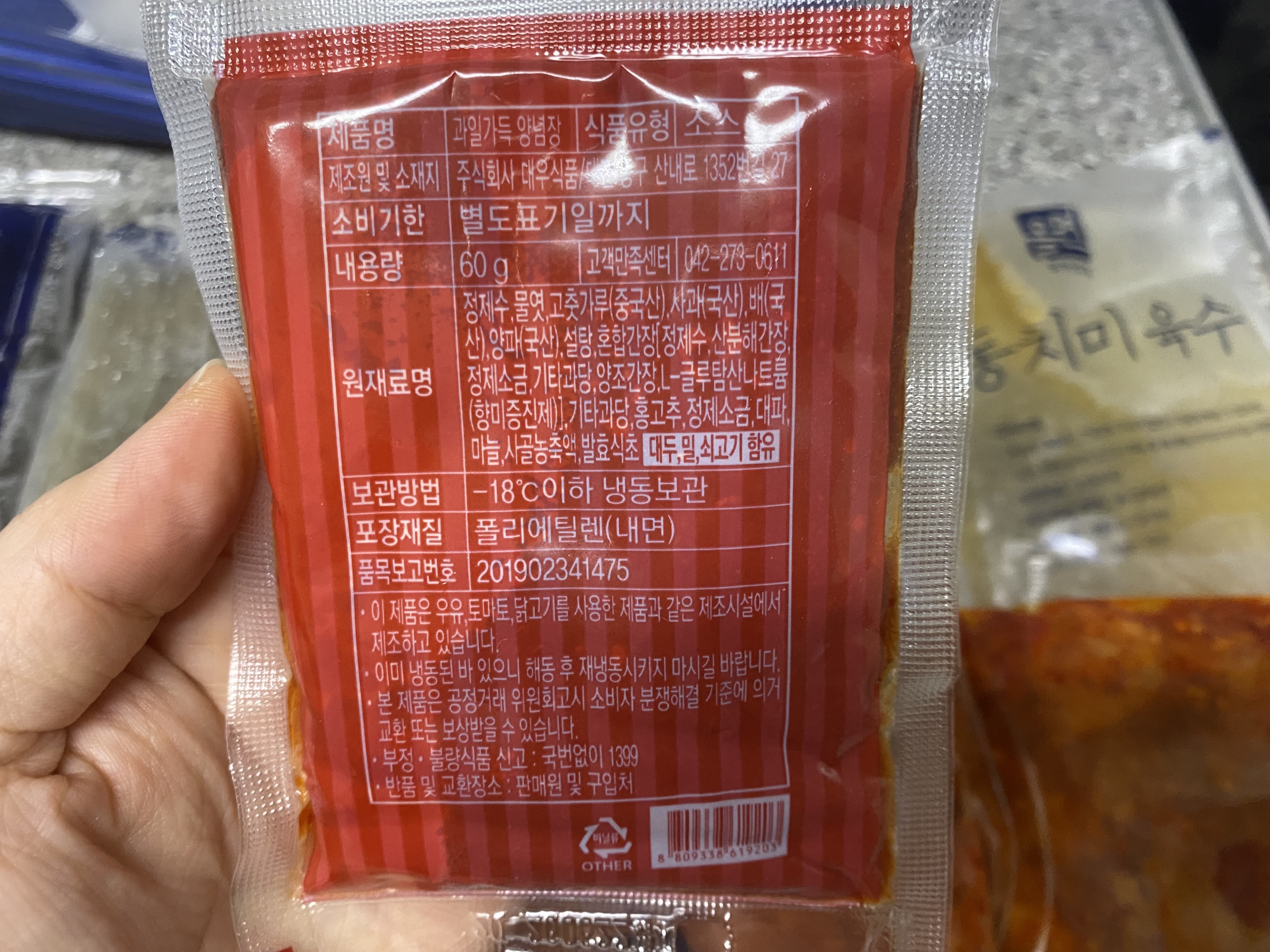 과일 양념장을 손에 들고 있고 뒷면 사진입니다. 양념장은 빨간색 입니다.