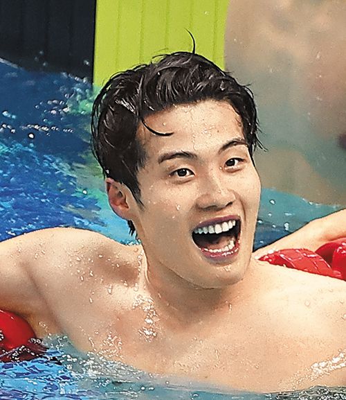 황선우 선수가 수영장 풀 안에서 환하게 웃고 있다