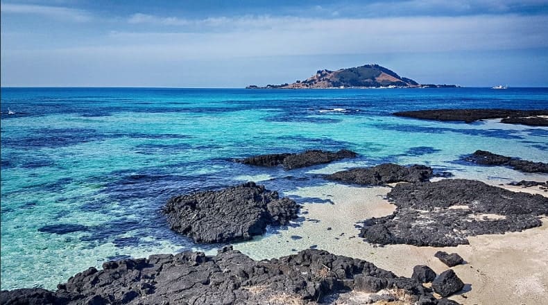 제주 협재해수욕장의 모래와 현무암의 조화 및 시원한 빛깔의 바다