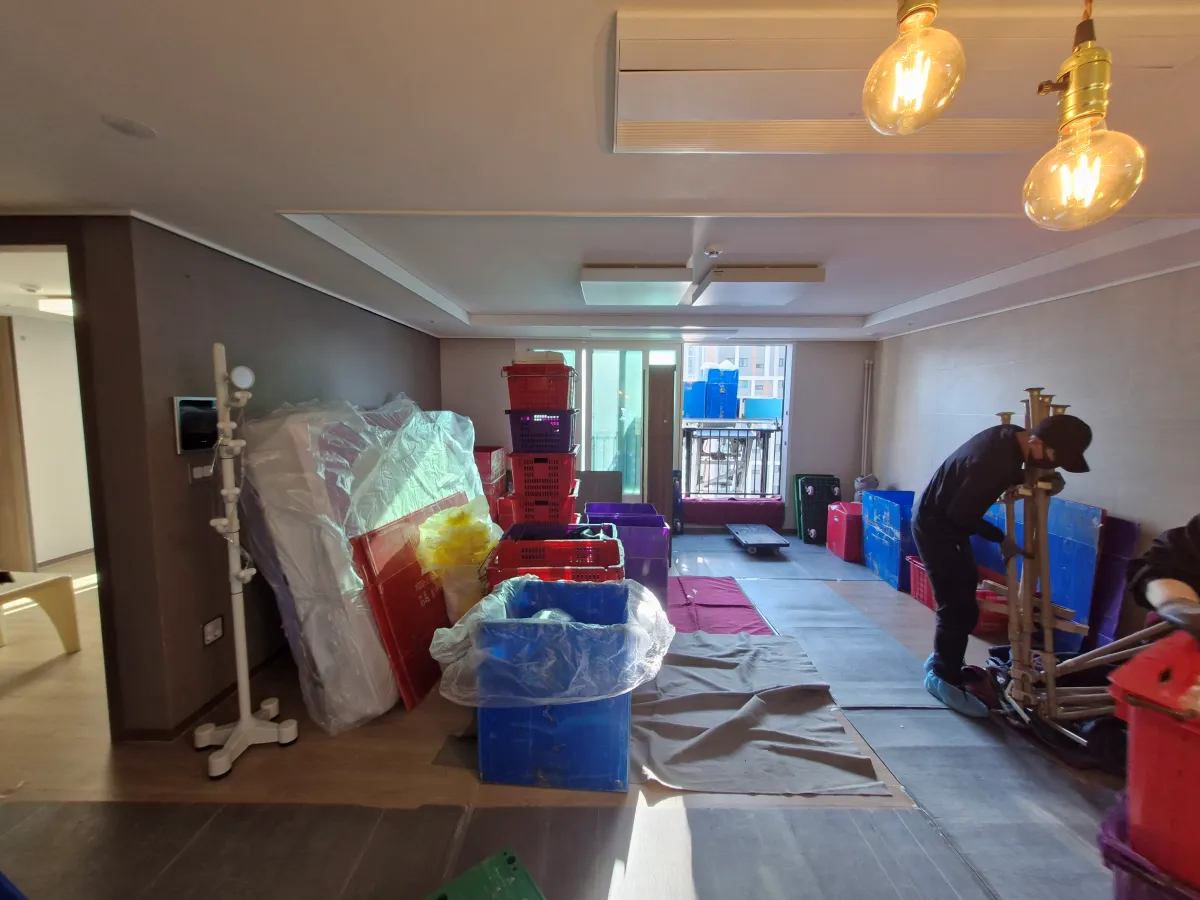 아파트-거실에서-짐을-운반하고-있는-남성