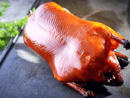 잘 구워진 오리구이가 통째로 있다. 껍질은 갈색이고 매끄럽다.