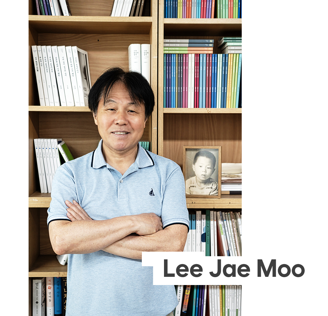 # 책장에 기대어 팔짱을 끼고있는 이재무 시인