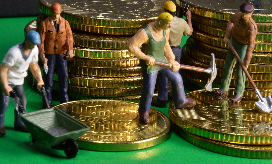 동전 위에 광부 인형들이 장비를 들고 서 있다.