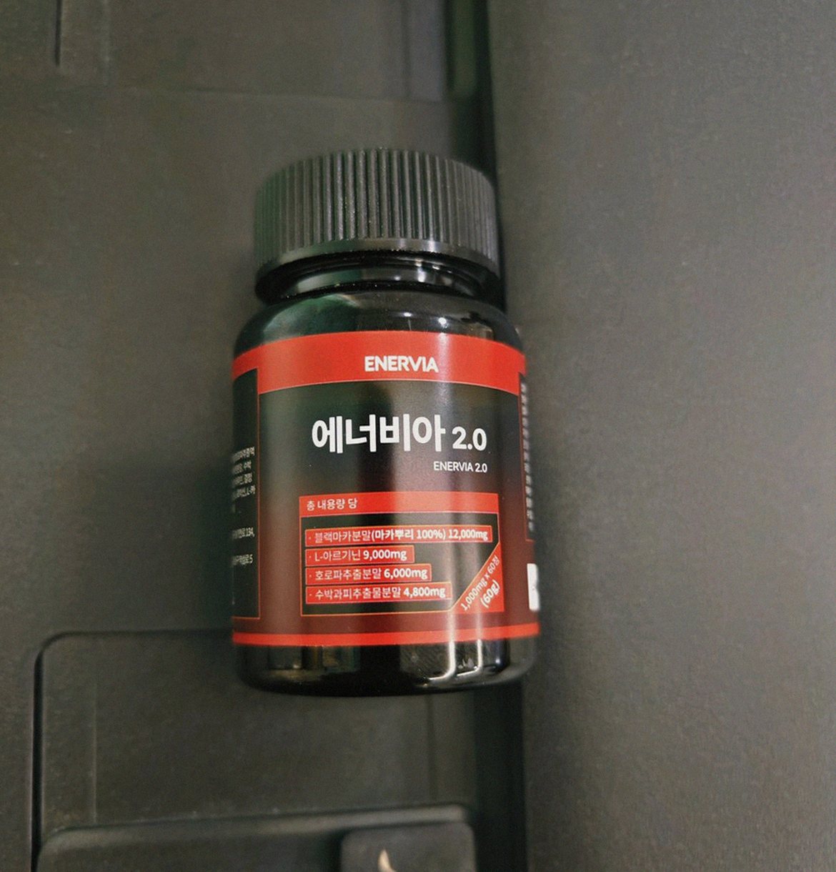 Korean Asian man holding supplement tablet showing size