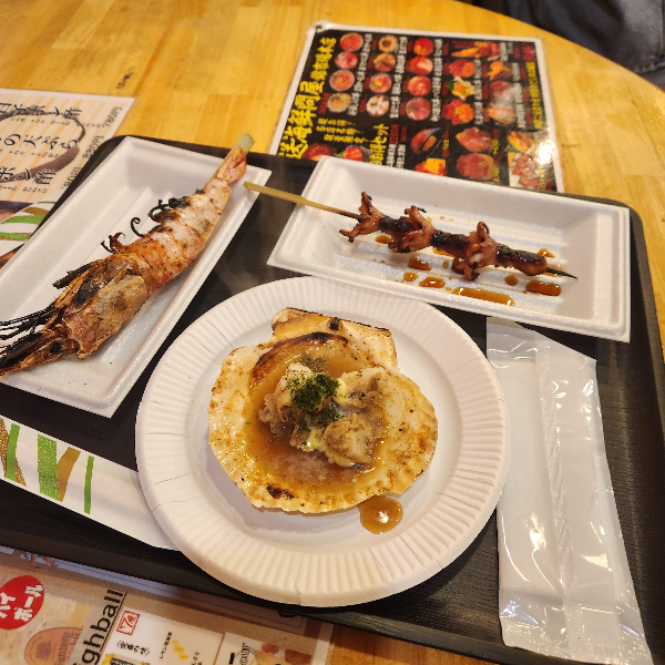 테이블 위에 새우와 가리비 그리고 작은 문어 꼬치 구이들