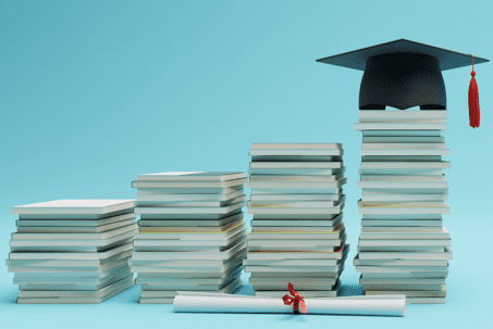 책이 쌓여 있고, 그 위에 학사모가 놓여져 있음