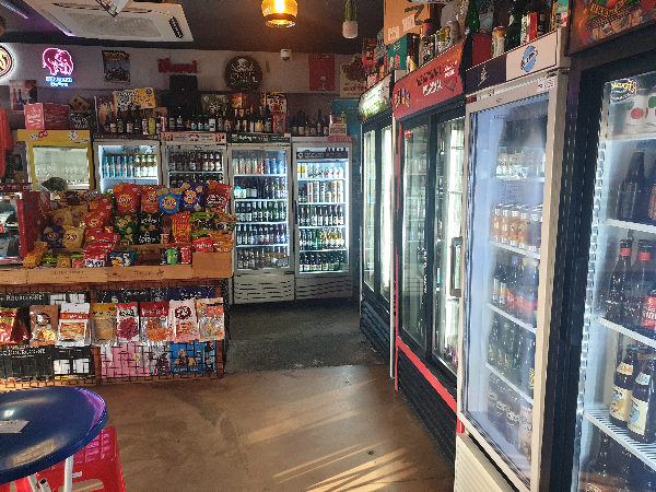 벽면에는 맥주 냉장고가 가운데는 안주 판매 테이블이 놓여있다.